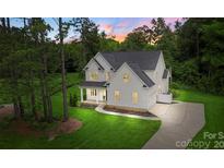 Beautiful two-story home featuring lush green lawn, manicured landscaping, and a long, private driveway at 3222 Player Ct, Salisbury, NC 28144