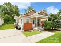 Charming single-story home featuring a cozy covered front porch and a well-maintained lawn at 379 Sharpe St, Mooresville, NC 28115
