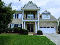 Charming two-story brick home with a well-manicured lawn, black shutters, and covered front porch at 408 Presidio Dr, Rock Hill, SC 29732