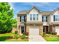 Two-story townhome with brick facade, attached garage, black shutters and landscaped front yard at 4107 Park South Station Blvd, Charlotte, NC 28210