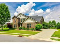 Charming brick two-story home with a lush green lawn and well-maintained landscaping on a sunny day at 4220 Thames Cir, Fort Mill, SC 29715