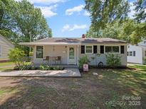 Charming single-story home with a covered porch, landscaped yard, and mature trees at 427 E 12Th Ave, Gastonia, NC 28054
