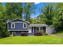 Charming blue split-level home with a well-manicured lawn, lush landscaping, and a welcoming front entrance at 6733 Candlewood Dr, Charlotte, NC 28210