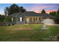 Charming single-story home featuring a covered front porch, gray siding, and a two-car garage at 7627 Sarah Dr, Denver, NC 28037