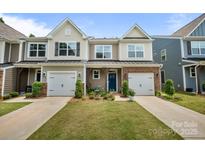 Charming townhome with well-maintained lawn, blue door, and attached garage at 8042 Saluda Dr # 3, Charlotte, NC 28269