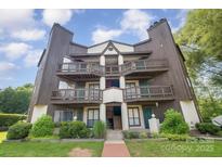 Three-story condo building with wooden balconies and well-manicured landscaping at 8135 Cedar Glen Dr, Charlotte, NC 28212