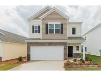 Two-story home features a two-car garage, stone accents, neutral siding, and a well manicured lawn at 1266 Langston Ln, Salisbury, NC 28144