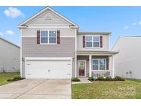 Charming two-story home with a manicured lawn, inviting porch, and attached garage at 1343 Kent Downs Sw Ave, Concord, NC 28027