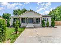 Charming white brick home featuring a covered porch and well-manicured landscaping at 157 Downey Lake Rd, Dallas, NC 28034