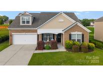 Charming brick home with a manicured lawn, attached garage, and inviting front porch and well landscaped beds at 163 Sassafras Rd, Mooresville, NC 28115