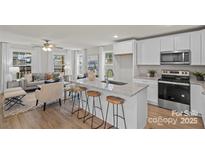 An open-concept kitchen with stainless appliances, granite countertops, and seating area with stools at 203 Putnam St, Shelby, NC 28152