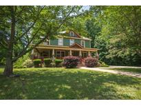 Charming two-story home featuring a welcoming front porch and lush landscaping at 215 W Eastway Drive Dr, Charlotte, NC 28213