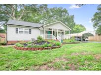 Charming single-story home with a welcoming front porch and landscaped garden at 2279 Cedar Oak Cir, Gastonia, NC 28052