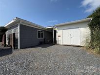 A charming home exterior featuring gray siding, a gravel driveway, and a detached white garage for secure parking at 333 Mount View Ln # 266 B, New London, NC 28127
