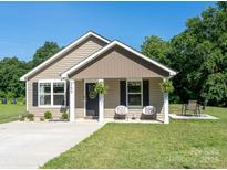 Charming single-story home with neutral siding, black door, and a well-manicured lawn and front patio seating area at 360 Sexton St, Kannapolis, NC 28081