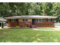 Charming brick home with manicured lawn and mature trees, offering great curb appeal at 3969 Sheffield Dr, Charlotte, NC 28205