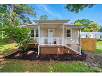 Charming single-story home featuring a cozy front porch and well-manicured lawn with mature trees at 407 Cummings St, Rock Hill, SC 29730