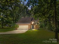 Charming brick home featuring a two-car garage and lush green lawn at 4444 Steepleton Way, Charlotte, NC 28215