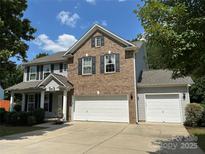 Charming two-story home with brick and vinyl siding, a three-car garage, and a well-maintained front yard at 5009 Brook Valley Run, Monroe, NC 28110