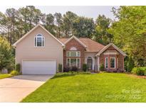 Charming two-story home featuring a well-manicured lawn and attached two-car garage at 7521 Plumcrest Ln, Harrisburg, NC 28075