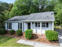 Charming single-story home with a well-maintained front yard, mature trees, and brick-accented entryway at 10016 Heathergate Ln, Mint Hill, NC 28227
