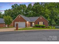 Charming one-story brick home featuring an attached garage and a well-manicured front yard at 103 Prestwick Ct, Salisbury, NC 28146