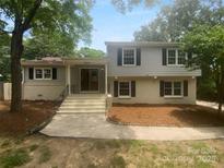 Charming two-story home features a brick and gray facade, welcoming entrance, and landscaped front yard at 10931 Osprey Dr, Charlotte, NC 28226
