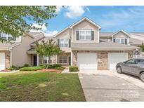 Charming townhouse with a well-maintained lawn, two-car garage, and a welcoming brick facade at 12452 Stratfield Place Cir, Pineville, NC 28134
