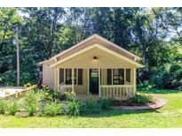 Charming home with a welcoming front porch, landscaped yard, and a backdrop of lush trees at 13414 Central Ave, Huntersville, NC 28078