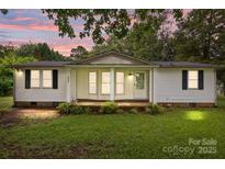 Charming one-story home featuring a covered porch and well-maintained front yard with mature landscaping at 200 Southwood Park Rd, Mooresville, NC 28117