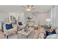 Inviting living room features stylish seating, a ceiling fan, and an open layout to the kitchen and dining area at 207 Putnam St, Shelby, NC 28152