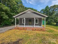Charming home exterior featuring a welcoming front porch with white pillars and a well-manicured lawn at 232 Branchwood Cir, Kings Mountain, NC 28086
