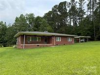 Charming single-story brick home with a covered front porch and carport on a spacious lawn at 2350 Grubb Ferry Rd, Salisbury, NC 28144