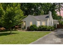 Charming single story home featuring a well-manicured lawn and lush trees providing shade and privacy at 3307 Draper Ave, Charlotte, NC 28205