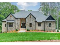 Stunning stone-and-brick home with a well-manicured lawn, covered entry, and gray shingle roof at 4028 Spindrift Cove Dr # 59 And 60, Denver, NC 28037