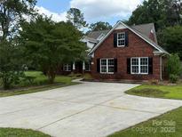 Charming brick home featuring a well-maintained yard and spacious driveway at 4402 Poxon Ln, Monroe, NC 28110