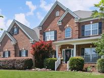 Two-story brick home featuring black shutters and well-manicured front yard at 6523 Alba Rose Ln, Huntersville, NC 28078
