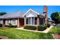 Charming brick exterior with a screened-in porch and manicured landscaping at 8538 Highland Glen Dr, Charlotte, NC 28269