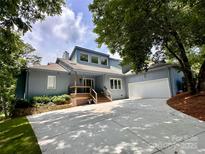 Stunning curb appeal with a well-manicured lawn and long driveway leading to the garage at 106 Boyter Ct, Cramerton, NC 28032