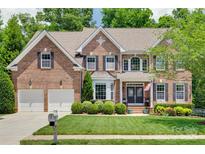 Charming brick home with a well-manicured lawn and a two-car garage, blending elegance with functionality at 1241 Brough Hall Dr, Waxhaw, NC 28173