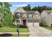 Charming two-story home with a well-manicured lawn and a two-car garage at 131 Cherry Bark Dr, Mooresville, NC 28117