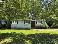 Charming single-story house with brick facade, complemented by lush greenery and ample shade trees at 1317 Moretz Ave, Charlotte, NC 28206