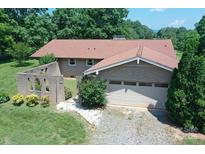 Charming brick home with a two-car garage nestled on a wooded lot and lush green lawn at 157 Blackberry Ln, Taylorsville, NC 28681