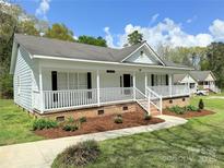 Charming one-story home with white picket fence, light blue siding, and brick foundation at 1675 Old Lynwood Cir, Lancaster, SC 29720