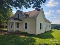 Inviting two-story home with a covered front porch, white shutters, and a well-maintained lawn at 275 Hiddenite Church Rd, Hiddenite, NC 28636