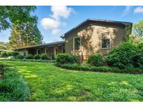 Charming single-story home with a lush green lawn, mature trees, and manicured landscaping at 3135 Lake Shore S Rd, Denver, NC 28037