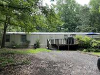 Exterior view of home featuring a deck, gravel driveway, and mature trees surrounding the property at 3910 Winter Rd, Rock Hill, SC 29730