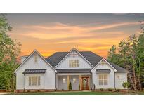 Stunning two-story home with white siding and a beautifully landscaped front yard at sunset at 4032 Brandy Creek Ct, Clover, SC 29710