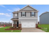 Charming two-story home featuring gray siding, a two-car garage, and a well-manicured lawn at 707 Olde England Dr, Lincolnton, NC 28092