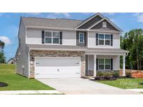 Charming two-story home with stone accents, white siding, black shutters, well-manicured lawn, and a two-car garage at 7311 Jerimoth Dr, Charlotte, NC 28215
